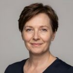 Портрет уверенного российского бизнесмена с дружелюбным взглядом на размытом нейтральном фоне в студии